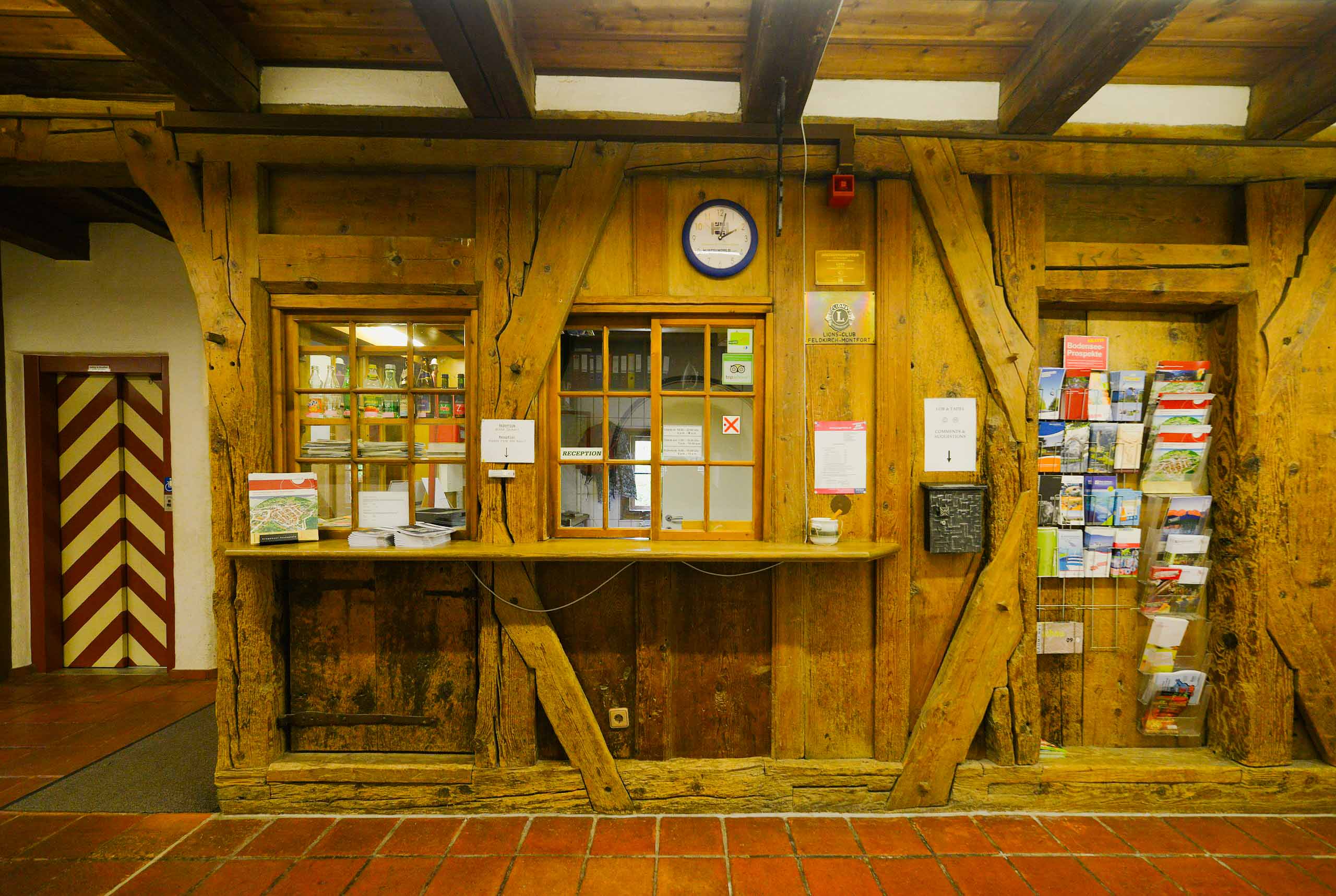 Empfang im Hostel Feldkirch mit historischer Holzrezeption, Fachwerkstruktur und Infobereich für Gäste